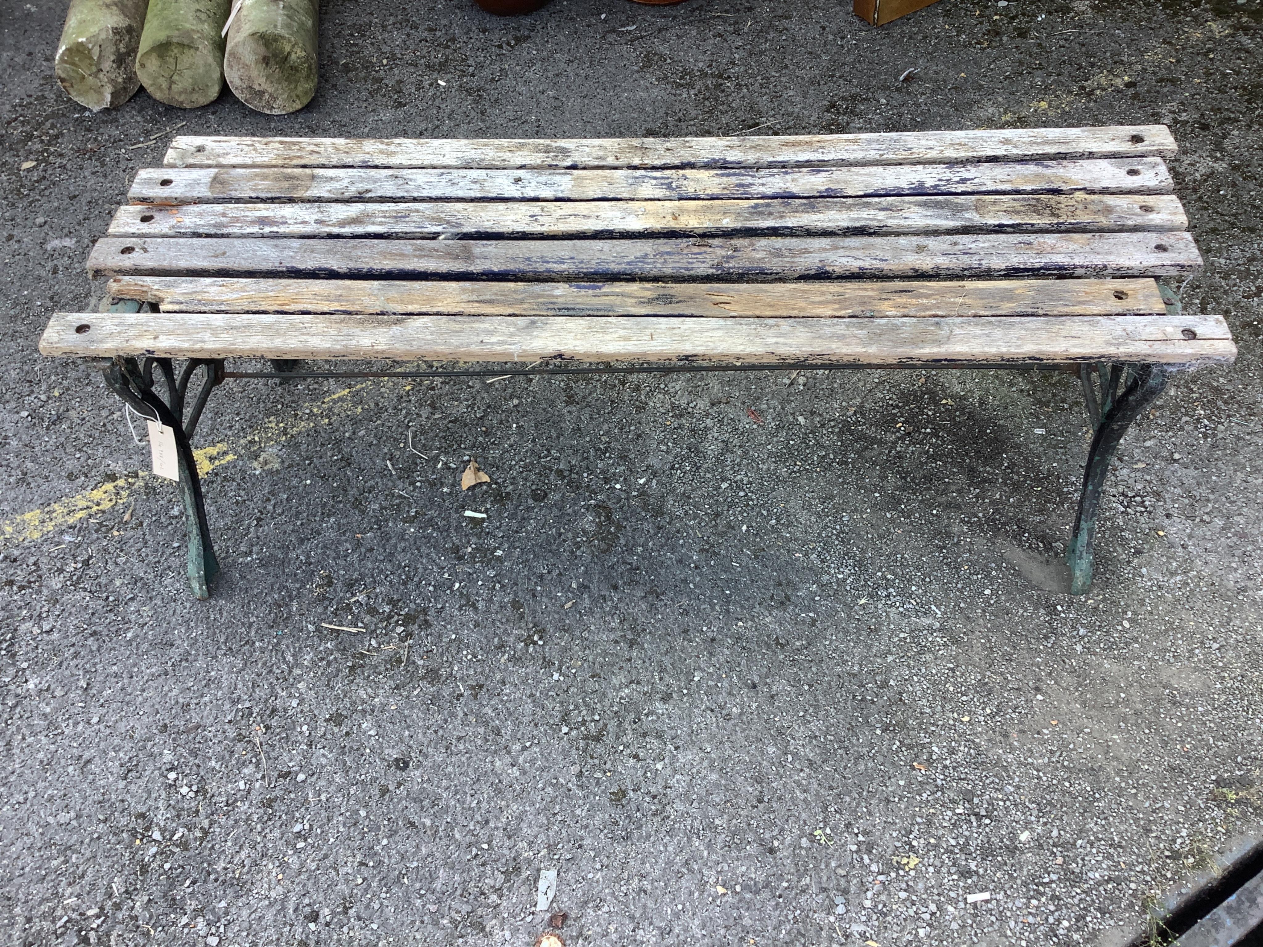 A Victorian slatted wooden bench with black painted aluminium end supports, height 40cm. (a.f.). Condition - poor